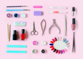 Set of various manicure and pedicure tools and accessories on pink background. Top view.