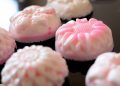 Finished homemade soap cake bars in pink and white on glass surface. This hobby home business is a great way to make aromatherepy, natural soaps that are healthier
