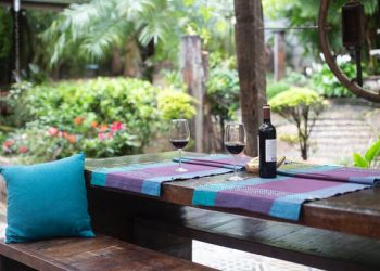 Table in backyard with wine on it