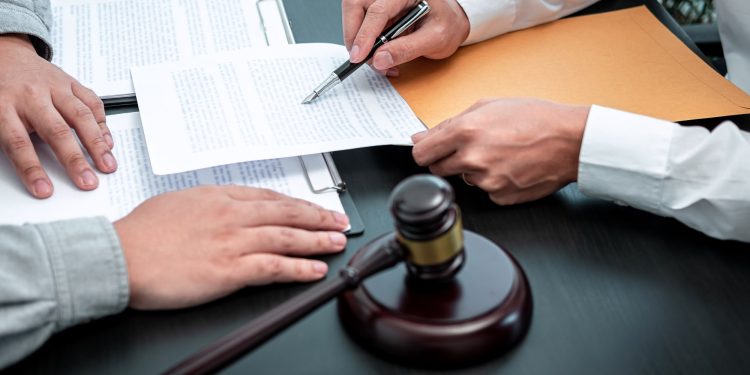 Male lawyer discussing negotiation legal case with client meeting with document contact in courtroom, law and justice concept.